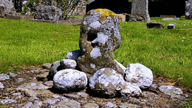 A cup-marked stone in Dundurn burial ground, Scotland.